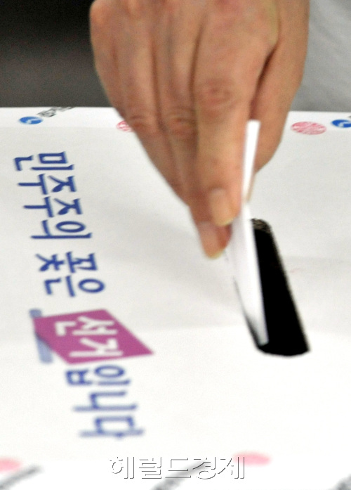 7,28 국회의원 재보선의 최대 관심지엳인 서울 은평(을) 지역 불광1동 제4투표소에서 28일 이른 오전  기표를 마친 한 유권자가 용지를 투표함에 넣고 있다.양동출dcyang@heraldm.com/100728/