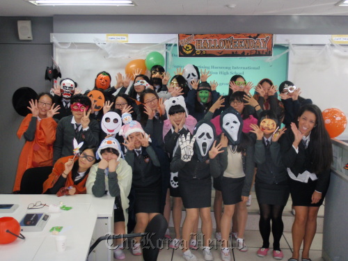 English teacher Jennifer Graham-Magill (right) and her students at Haeseong International Convention High School pose for a picture at a Halloween event in October.  Haeseong International Convention High School