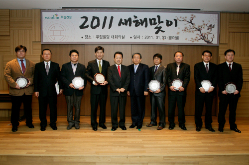 심영섭(왼쪽 다섯번째) 우림건설 회장 등 이 회사 경영진과 우수협력업체 대표가 지난 3일 시무식을 마치고 기념촬영하고 있다.  <사진제공= 우림건설>
