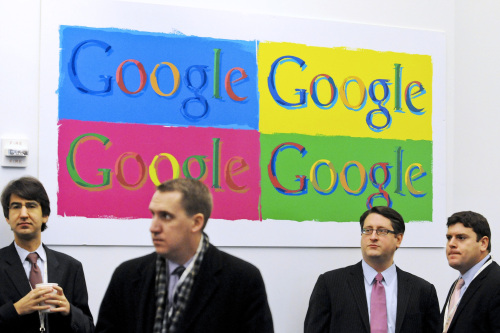 People stand under Google Inc. signage before a news conference at the company's offices in New York, U.S., on Dec. 16..  (Bloomberg-Yonhap)
