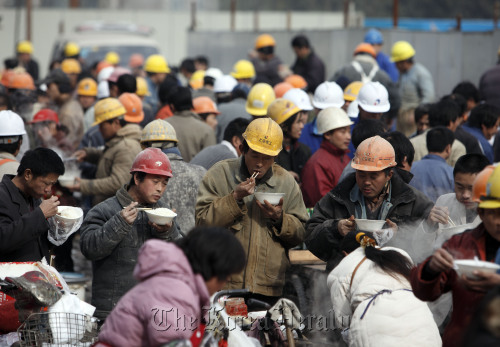 Workers gather for lunch at a makeshift eating area near a construction site in Shanghai.  Bloomberg