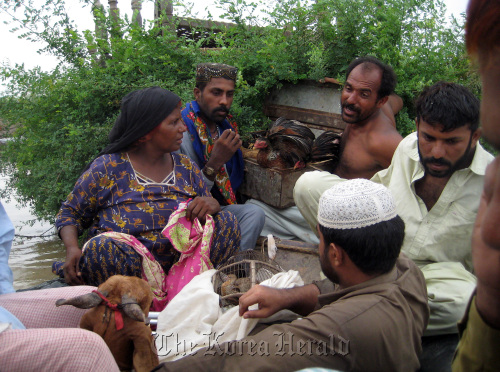 People insist on bringing their animals, including chickens and a goat, as they are rescued by the Pakistan navy.  MCT-Yonhap