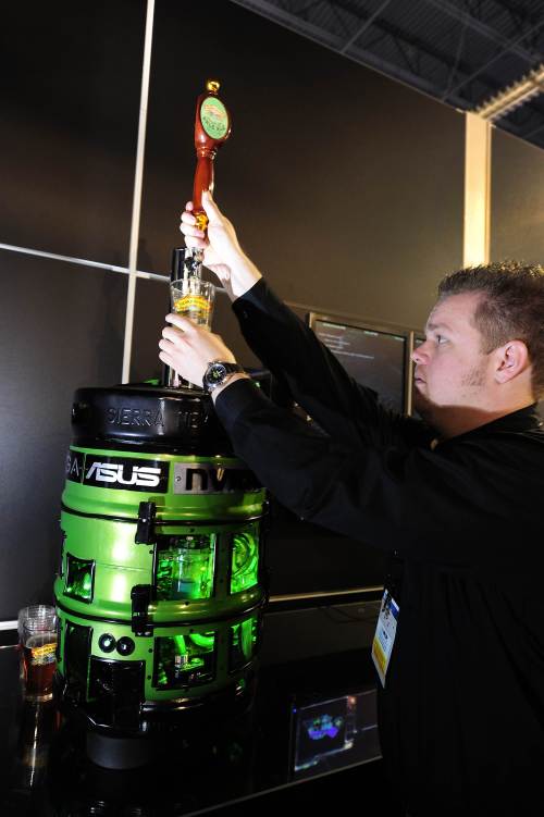 <YONHAP PHOTO-0543> Kris Rey pours beer from a custom-made computer/beer dispenser at the Nvidia booth at the 2011 International Consumer Electronics Show (CES) January 9, 2011 in Las Vegas, Nevada. The high-powered gaming computer has two Nvidia GeForce GTX 58 video cards in SLI and for a processor the newest Intel i7 Sandy Bridge chip. It also has a 2.5 gallon (about 40 glasses of beer) beer reservoir with an independent refrigerator system and inline CO2 (carbon dioxide) system for fresh, carbonated, cold beer. The one-of-a-kind computer/beer dispenser will be auctioned for charity. AFP PHOTO / Robyn Beck /2011-01-10 10:44:18/ <저작권자 ⓒ 1980-2011 ㈜연합뉴스. 무단 전재 재배포 금지.>
Kris Rey pours beer from a custom-made computer/beer dispenser at the Nvidia booth at the 2011 International Consumer Electronics Show on Sunday in Las Vegas, Nevada.  AFP-Yonhap News