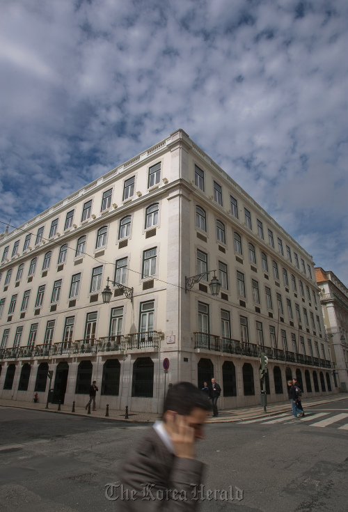 A pedestrian walks past the Central Bank of Portugal in Lisbon.   Bloomberg
