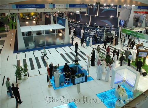 Visitors look around the Masdar stand at the World Future Energy Summit 2010.  Masdar