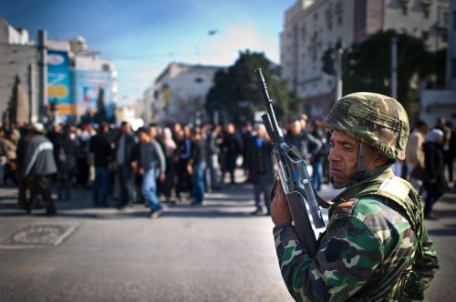 <YONHAP PHOTO-0099> A soldier stands guard as people demonstrate during a protest in central Tunis on January 17, 2011. Tunisian protesters called for the abolition of ousted president Zine El Abidine Ben Ali's ruling party on January 17 amid a chaotic power vacuum as politicians prepared a government of national unity. Hundreds of people rallied in Tunis and there were similar protests in Sidi Bouzid and Regueb in central Tunisia -- two towns at the heart of the movement that forced Ben Ali to resign and flee on Friday after 23 years in power. AFP PHOTO / MARTIN BUREAU /2011-01-18 00:44:29/ <저작권자 ⓒ 1980-2011 ㈜연합뉴스. 무단 전재 재배포 금지.>
A soldier stands guard as people demonstrate during a protest in central Tunis on Monday.  AFP-Yonhap News