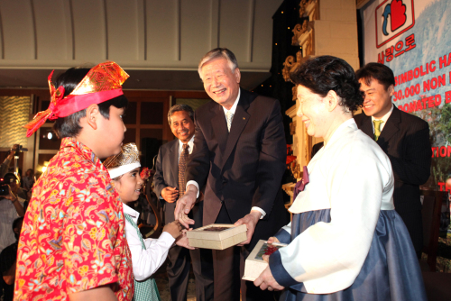 Booyoung Group founder and chairman Lee Joong-keun (center)
gives souvenirs to an Indonesian student at the Indonesian
education ministry after donating 10,000 digital pianos and
30,000 blackboards in Jakarta, Thursday. (Yonhap News)