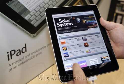 A customer demonstrates Apple Inc.’s App Store on an iPad tablet computer at a Best Buy store in Orem, Utah. Bloomberg