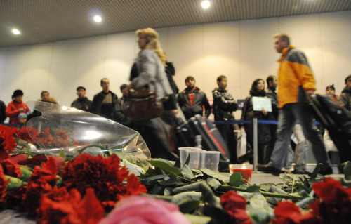 <YONHAP PHOTO-0509> (110125) -- MOSCOW, Jan. 25, 2011 (Xinhua) -- Passengers pass by flowers and candles laid for victims of Monday's deadly terrorist attack at the Domodedovo Airport in Moscow, capital of Russia, Jan. 25, 2011. At least 35 people were killed and over 130 others injured in the explosion at Moscow's Domodedovo airport on Monday, the Russian Health Ministry said. (Xinhua/Liu Kai) (zw) /2011-01-26 08:10:21/ <저작권자 ⓒ 1980-2011 ㈜연합뉴스. 무단 전재 재배포 금지.>
Passengers pass by flowers and candles laid for the victims of Monday’s deadly terrorist attack at the Domodedovo Airport in Moscow, Tuesday.  Xinhua-Yonhap News