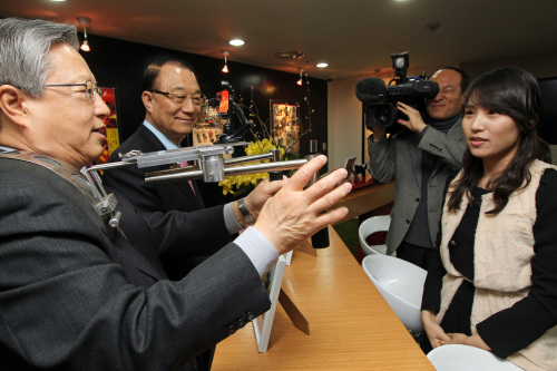 <YONHAP PHOTO-0940> 휴대전화로 영상콘텐츠 제작할려면? (서울=연합뉴스) 진성철 기자 = 26일 서울 양천구 목동 KT정보전산센터에서 열린 '올레 미디어 스튜디오' 개소식에서 최시중 방송통신위원장(가운데)과 KT 이석채 회장(왼쪽)이 휴대전화로 영상촬영을 할 수 있게 도와주는 보조장비들을 직접 사용해 보고 있다. 2011.1.26 zjin@yna.co.kr/2011-01-26 12:14:00/ <저작권자 ⓒ 1980-2011 ㈜연합뉴스. 무단 전재 재배포 금지.>
Korea Communications Commission chairman Choi See-joong (second from left) and KT chairman Lee Suk-chae (left) test the supplementary devices which enable the shooting of images with mobile phones at the launching ceremony of KT’s Olleh media center in southwestern Seoul on Wednesday. Yonhap News