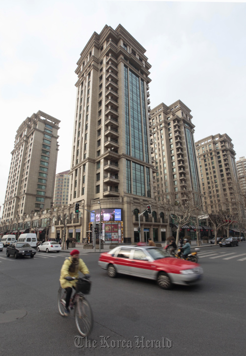 Traffic pases in front of a housing complex in Shanghai.  Bloomberg
