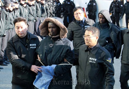 30일 오전 아라비아해에서 삼호주얼리호를 납치했다  우리 해군의 구출작전으로 생포돼 아랍에미레이트 왕실 전용기를 타고 부산으로 압송된 소말리아 해적 5명이 조사를 받기 위해 남해지방해양경찰청으로 들어오고 있다.<br />이날 김해공항에서 군으로부터  남해해경청이 해적의 신병을 인수 받았으며, 무장경찰 40여명과 특공대 전술차량 등 차량 6대, 헬기 1대를 동원하는등 특별호위를 하였다.<br />부산=이상섭기자/babtong@heraldm.com 2011.01.30
Somali pirates are taken to a regional headquarters of the Korea Coast Guard in Busan on Sunday.  Lee Sang-sup/The Korea Herald
