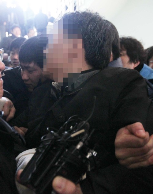 <YONHAP PHOTO-1388> '대전 경찰母 피살사건' 용의자 아들 체포 (대전=연합뉴스) 양영석 기자 = 대전 둔산경찰서는 28일 "'경찰관 어머니 강도치사 사건'의 유력한 용의자로 피해자의 아들인 경찰 고위간부 이모씨를 체포했다"고 밝혔다. 이모씨가 둔산서 진술녹화실로 들어서고 있다.2011.1.28 youngs@yna.co.kr/2011-01-28 12:19:01/ <저작권자 ⓒ 1980-2011 ㈜연합뉴스. 무단 전재 재배포 금지.>
A detective charged with killing his mother is taken into a police station in Daejeon on Friday. Yonhap News
A detective charged with killing his mother is taken into a police station in Daejeon on Friday. Yonhap News