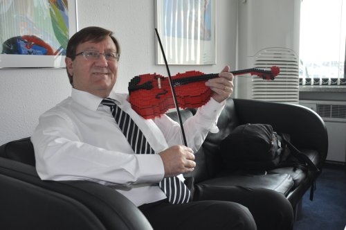 Danish Ambassador Peter Lysholt Hansen plays
a violin made from Lego parts which could be
used for the educational development of young
children. (Yoav Cerralbo/The Korea Herald)