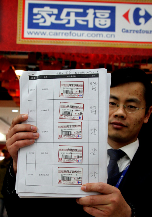 <YONHAP PHOTO-2058> (110130) -- SHANGHAI, Jan. 30, 2011 (Xinhua) -- A Carrefour staff presents re-examined price tag in a store in Shanghai, east China, Jan. 30, 2011. Local government set up an inspection team to monitor the progress of a fine of 500,000 RMB, a record-high administrative punishment to three Carrefour stores for their deceptive pricing practices. (Xinhua/Chen Fei) (cxy)/2011-01-30 22:38:30/ <저작권자 ⓒ 1980-2011 ㈜연합뉴스. 무단 전재 재배포 금지.>
A Carrefour employee presents a re-examined price tag in a store in Shanghai on Sunday.
Xinhua-Yonhap News