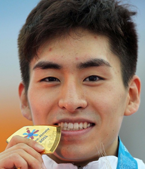 Speed skater Lee Seung-hoon bites his gold medal after winning the men‘s 5,000-meter race at the Asian Winter Games in Kazakhstan on Monday. (Yonhap News)
