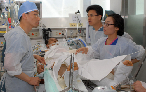 <YONHAP PHOTO-0706> 석 선장 회진하는 이국종 교수 (수원=연합뉴스) 1일 오전 경기도 수원 아주대학교병원에서 아주대 이국종(왼쪽) 교수가 삼호주얼리호 석해균 선장의 상태를 살펴보고 있다. 2011.2.1 << 아주대학교 제공 >> drops@yna.co.kr http://blog.yonhapnews.co.kr/geenang/2011-02-01 11:41:12/ <저작권자 ⓒ 1980-2011 ㈜연합뉴스. 무단 전재 재배포 금지.>
Lee Guk-jong (left) and other medical staff take care of Seok Hae-kyun, the wounded captain of a rescued South Korean freighter, at Ajou University Hospital in Suwon, Gyeonggi Province, Tuesday.    Ajou University Hospital