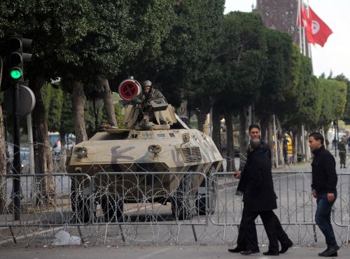 <YONHAP PHOTO-0359> Tunisian people walk past a barricade behind which Tunisian military and security forces stand guard on February 5, 2011 in Tunis. EU lawmakers meet with Tunisia's interim government today in post-crisis talks following the regional bloc's pledge to help the country's democratic transition. AFP PHOTO / FETHI BELAID /2011-02-06 06:45:18/ <저작권자 ⓒ 1980-2011 ㈜연합뉴스. 무단 전재 재배포 금지.>
People walk past a barricade behind which Tunisian military and security forces stand guard on Saturday in Tunis.  AFP-Yonhap News
People walk past a barricade behind which Tunisian military and security forces stand guard on Saturday in Tunis.  AFP-Yonhap News
