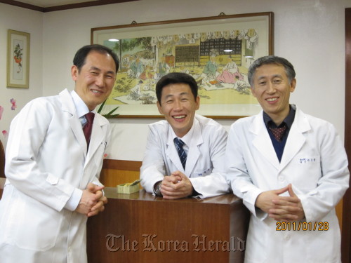 Park Su-hyun (right) poses with his brothers Sae-hyun (center) and Tae-hyun at his clinic. Park Su-hyun