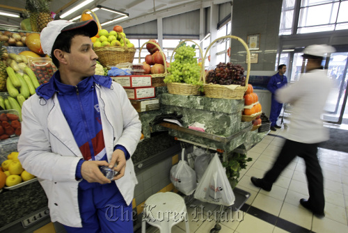 A trader stands by the fruit stall waiting for customers at the Dorogomilovsky food market in Moscow.  Bloomberg