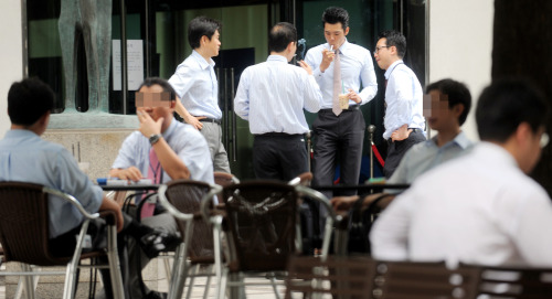 여의도 증권가 흡연 스케치./안훈기자 rosedale@ 2010.07.20
People in Seoul smoke cigarettes outside a building.  The Korea Herald