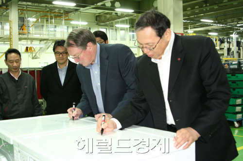 LG전자가 7일 캐나다 상업용 세탁 설치ㆍ공급 1위 업체인 코인어매틱사와 상업용 세탁기 공급 및 공동 마케팅 진행 계약을 체결한 가운데 LG전자 세탁기사업부장 조성진(오른쪽) 부사장이 캐나다 업체 관계자와 함께 계약서에 사인을 하고 있다.