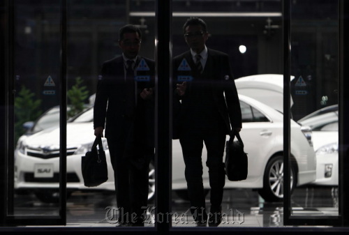 Men exit Toyota Motor Corp.’s Tokyo headquarters.  Bloomberg