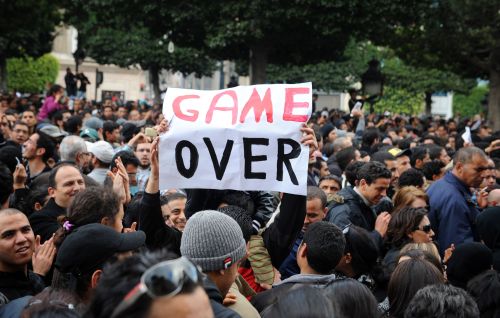 <YONHAP PHOTO-1458> (FILES) In this photograph taken on January 14, 2011 a Tunisian demonstrator holds a placard reading "Game Over" during a rally in front of the country's Interior ministry in Tunis to demand President Zine El Abidine Ben Ali's resignation. Mass protests sparked partly by poverty and unemployment erupted across the country on January 14, 2011 prompting strongman president Zine El Abidine Ben Ali to flee the country. AFP PHOTO / FETHI BELAID /2011-02-13 21:12:33/ <저작권자 ⓒ 1980-2011 ㈜연합뉴스. 무단 전재 재배포 금지.>
A Tunisian demonstrator holds a placard during a rally in front of the country’s Interior Ministry in Tunis to demand President Zine El Abidine Ben Ali’s resignation on Jan. 14.  AFP-Yonhap News
