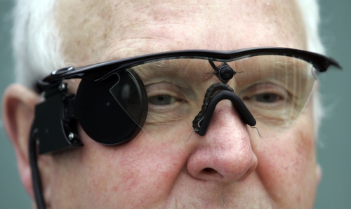 <YONHAP PHOTO-2598> In this photo taken Saturday, Feb. 12, 2011,Eric Selby poses for a photograph with a "sight" camera fitted in a pair of glasses, which works in conjunction with an artificial retina implant called the Argus II fitted in his right eye, enabling him to detect light, in Coventry, England. For two decades, Eric Selby, 68, had been completely blind and dependent on a guide dog to get around. But after having an artificial retina put into his right eye, he can detect ordinary things like the curb and pavement when he's walking outside. (AP Photo/Martin Cleaver)/2011-02-14 19:19:17/ <저작권자 ⓒ 1980-2011 ㈜연합뉴스. 무단 전재 재배포 금지.>
Eric Selby poses for a photograph with a “sight” camera fitted in a pair of glasses, which works in conjunction with an artificial retina implant called the Argus II fitted in his right eye, enabling him to detect light, in Coventry, England.
AP-Yonhap News