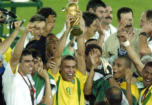 <YONHAP PHOTO-0720> ADDS THIRD SENTENCE - FILE - In this June 30, 2002, file photo, Brazil's Ronaldo (9) holds up the World Cup trophy as he celebrates with teammates after beating Germany 2-0 in the 2002 World Cup final in Yokohama, Japan. Ronaldo scored both goals. Ronaldo says on Monday, Feb. 14, 2011, he is retiring from soccer because he can't stay fit anymore, ending a stellar 18-year career in which he thrived with Brazil and some of Europe's top clubs. (AP Photo/David Guttenfelder, file)/2011-02-15 08:08:28/ <저작권자 ⓒ 1980-2011 ㈜연합뉴스. 무단 전재 재배포 금지.>
Ronaldo holds up the World Cup trophy in 2002.  AP-Yonhap News