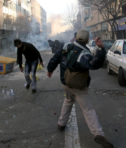 <YONHAP PHOTO-0639> This photo, taken by an individual not employed by the Associated Press and obtained by the AP outside Iran shows Iranian protestors throwing stones at ant-riot police officers, during an anti-government protest in Tehran, Iran, Monday, Feb. 14, 2011. Eyewitnesses report that sporadic clashes have erupted in central Tehran's Enghelab or Revolution square between security forces and opposition protesters. The demonstrators were chanting "death to the dictator," referring to the country's hardline president that the opposition believes was reelected through fraud in 2009. (AP Photo) EDITORS NOTE AS A RESULT OF AN OFFICIAL IRANIAN GOVERNMENT BAN ON FOREIGN MEDIA COVERING SOME EVENTS IN IRAN, THE AP WAS PREVENTED FROM INDEPENDENT ACCESS TO THIS EVENT/2011-02-15 08:01:55/ <저작권자 ⓒ 1980-2011 ㈜연합뉴스. 무단 전재 재배포 금지.>
Iranian protesters throw stones at anti-riot police officers during an anti-government protest in Tehran on Monday.  AP-Yonhap News