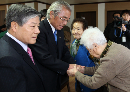 Former Korean Justice Minister Kim Sungho
(left) and former Japanese Justice
Minister Sugiura Seikan solace comfort
women forced into sexual slavery for the
Japanese troops during World War II at the
House of Sharing in Gwangju, Gyeonggi
Province, Sunday. (Yonhap News)