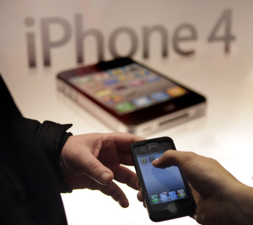 A Verizon Wireless employee helps a new iPhone user in New York, Thursday, Feb. 10, 2011.  (AP-Yonhap News)