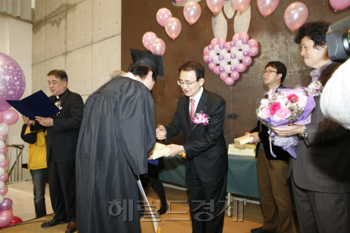 이헌식 삼성코닝정밀소재 사장이 노숙인 인문학 과정 졸업생들에게 선물을 전달하고 있다