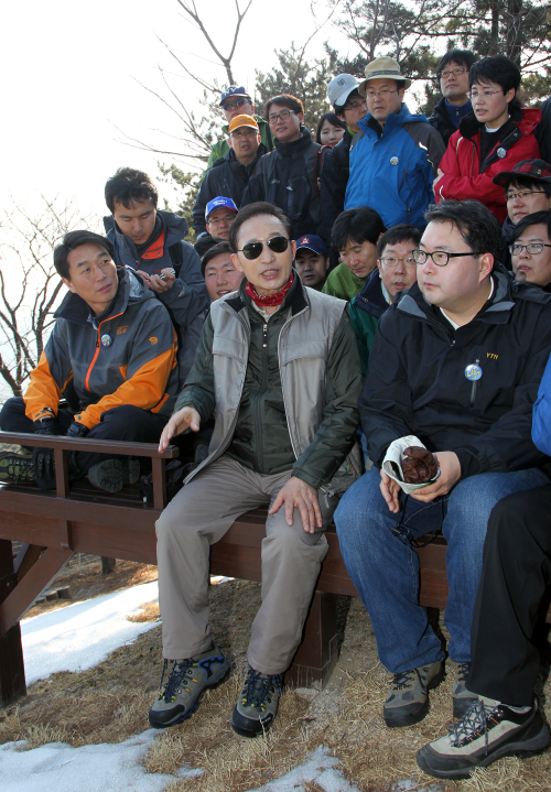 AIN’T NO MOUNTAIN HIGH ENOUGH — President Lee Myung-bak shakes hands with a climber at Mount Bukak in Seoul on Sunday.
(Chung Hee-cho/The Korea Herald)