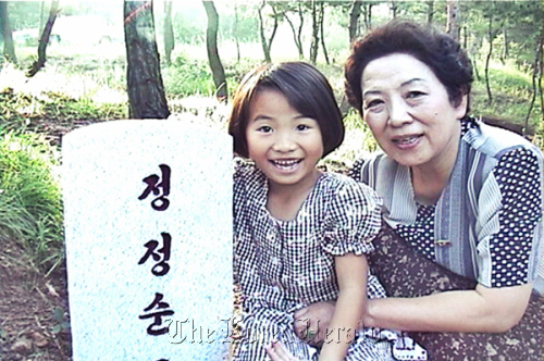 Yang’s niece, Son-hwa (left), poses with her grandmother (Yang’s mother) at her mother’s grave in North Korea in the 1990s. Kinoeye DMC