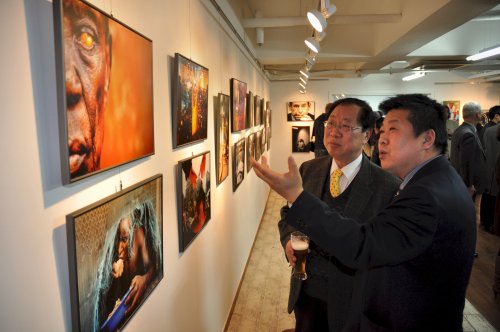 Daegu Photo Biennale president Lee Yong-hwan (right) and Czech
Tourism director Choi Soo-myung discuss the news events behind
the pictures displayed at the Czech Press Photo exhibition at
Castle Praha in Hongdae, Seoul. (Yoav Cerralbo/The Korea Herald)