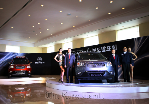 Ssangyong Motor Co. court receivership managers Lee Yoo-il (second from left) and Park Young-tae (third from right) pose with the Korando C at the launch event in Jeju on Tuesday.  Ssangyong Motor Co.