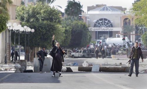 <YONHAP PHOTO-0274> A gunman flashes the victory sign to beckon foreign journalists to come closer past barricades to see the situation in the main square in Zawiya, 30 miles (50 kilometers) west of Tripoli, in Libya Sunday, Feb. 27, 2011. Hundreds of armed anti-government forces backed by military defectors in Zawiya, the city closest to the capital Tripoli, prepared Sunday to repel an expected offensive by forces loyal to Moammar Gadhafi who are surrounding the city. (AP Photo/Ben Curtis)/2011-02-28 06:43:23/ <저작권자 ⓒ 1980-2011 ㈜연합뉴스. 무단 전재 재배포 금지.>
A gunman flashes a victory sign to beckon foreign journalists to come closer to see the situation in the main square in Zawiya, west of Tripoli, in Libya on Sunday.  AP-Yonhap News