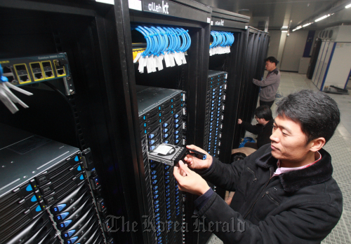 <YONHAP PHOTO-0572> KT 클라우드데이터센터 (서울=연합뉴스) KT는 지난 11월 클라우드 컴퓨팅 서비스를 위해 전용데이터센터인 천안데이터센터를 오픈하고 본격적 서비스에 들어갔다고 8일 밝혔다. KT 직원들이 8일 천안 클라우드데이터센터에서 서버 등을 점검하고 있다. 2010.12.8 photo@yna.co.kr/2010-12-08 09:36:39/ <저작권자 ⓒ 1980-2010 ㈜연합뉴스. 무단 전재 재배포 금지.>
Workers check server computers at a KT data center in Seoul.       The Korea Herald