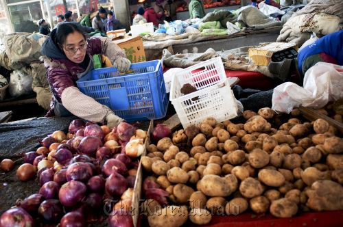 Vendors sell vegetables at a produce market in Beijing.  Bloomberg