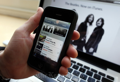 An Apple Inc. iPhone runs the iTunes music application.   Bloomberg