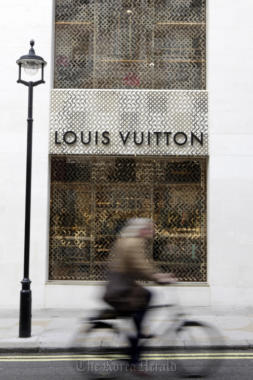 A cyclist passes a Louis Vuitton store on New Bond Street, in London.  Bloomberg