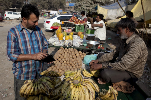 A customer looks at a fruit stall in New Delhi, India. Bloomerg