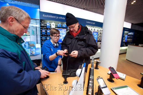 Customers look at Nokia Oyj E7 mobile handsets for sale in a Nokia store in Helsinki.  Bloomberg
