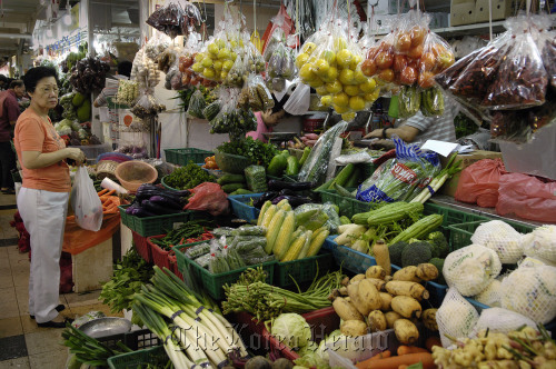A shopper buys vegetables at a wet market in Singapore.  Bloomberg