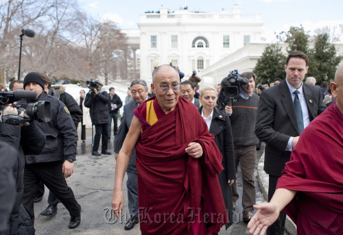 Dalai Lama (center) departs after speaking to the media at the White House in Washington, D.C.  Bloomberg