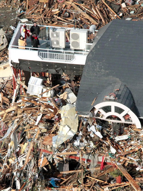 <YONHAP PHOTO-1478> ALTERNATE CROP OF TOK863 - People wait for rescue on the rooftop of a ruined building tangled with tsunami-drifted debris in Rikuzentakada, Iwate Prefecture, Saturday morning, March 12, 2011 after Japan's biggest recorded earthquake slammed into its eastern coast Friday. (AP Photo/Kyodo News) MANDATORY CREDIT, NO LICENSING ALLOWED IN CHINA, HONG KONG, JAPAN, SOUTH KOREA AND FRANCE/2011-03-12 12:01:52/ <저작권자 ⓒ 1980-2011 ㈜연합뉴스. 무단 전재 재배포 금지.>
People wait for rescue on the rooftop of a ruined building tangled with tsunami-drifted debris in Rikuzentakada, Iwate Prefecture, Saturday.   AP-Yonhap News