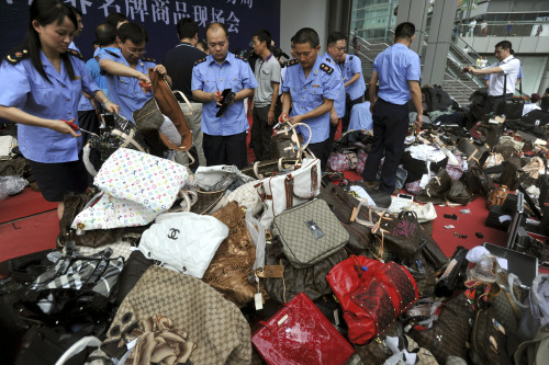 <YONHAP PHOTO-1138> FILE - In this Aug. 16, 2010 file photo, Chinese business administration officers cut fake luxury branded handbags during a mass elimination of counterfeit products in southwest China's Chongqing city. Chinese authorities have arrested 3,001 people in their latest crackdown on rampant product piracy and seized fake or counterfeit medicines, liquor, mobile phones and other goods, officials said Sunday, March 13, 2011. (AP Photo/File) CHINA OUT /2011-03-13 15:00:50/ <저작권자 ⓒ 1980-2011 ㈜연합뉴스. 무단 전재 재배포 금지.>
Chinese business administration officers cut fake luxury branded handbags during a mass elimination of counterfeit products in southwest China’s Chongqing city.  AP-Yonhap News