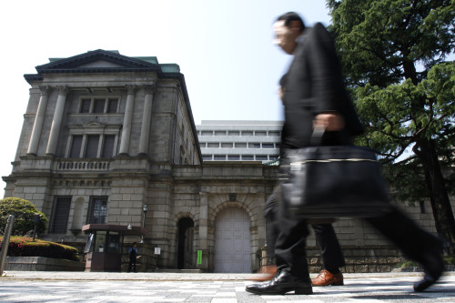 Pedestrians walk past the Bank of Japan headquarters in Tokyo. Bloomberg